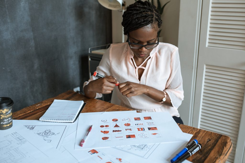 Business women sitting at desk analyzing charts. Photo by Rodnae via Pexels