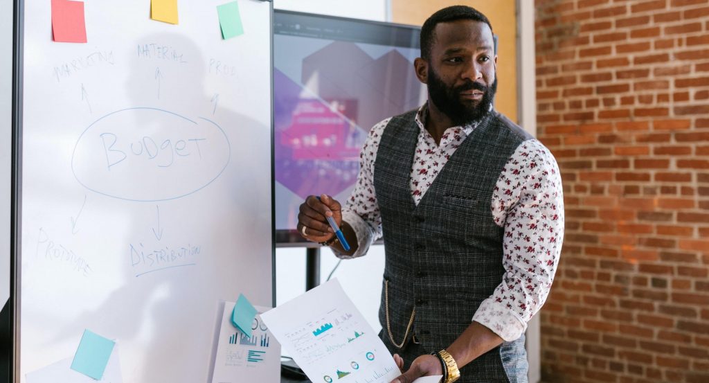 Entrepreneur standing and presenting in front of white board